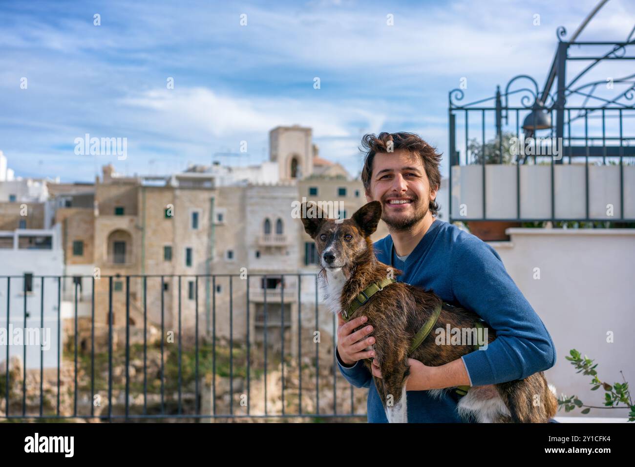 Mann mit braunem Hund, der in die Kamera schaut und lächelt Stockfoto