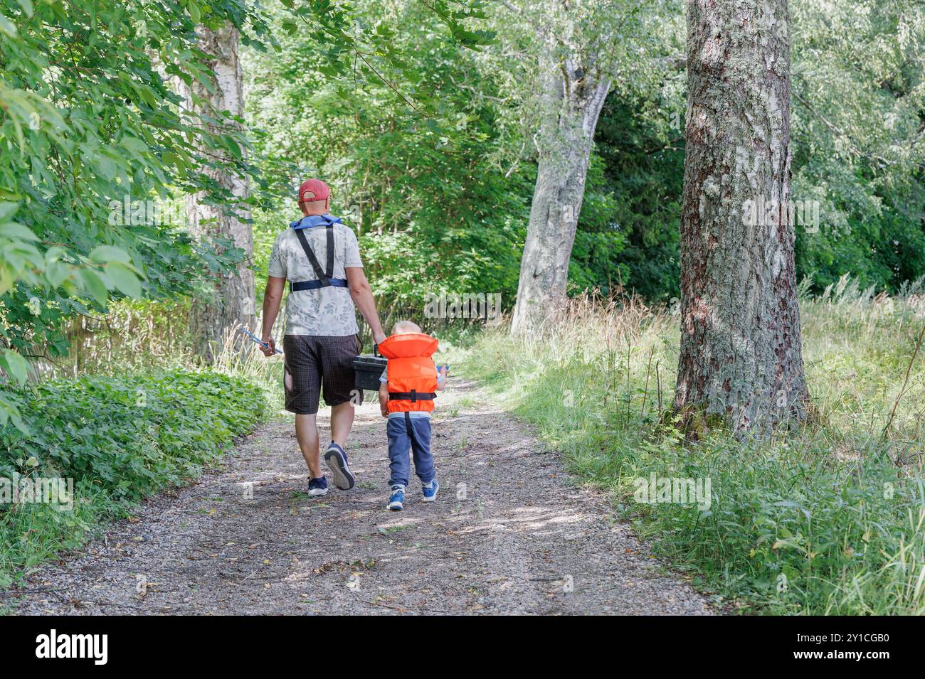 Mann und Kind gehen zusammen auf einem Waldweg Stockfoto