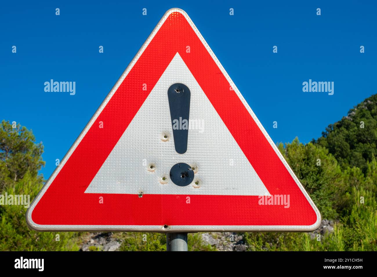 Dreieckiges Verkehrszeichen mit Ausrufezeichen und Einschusslöchern. Montenegro Stockfoto