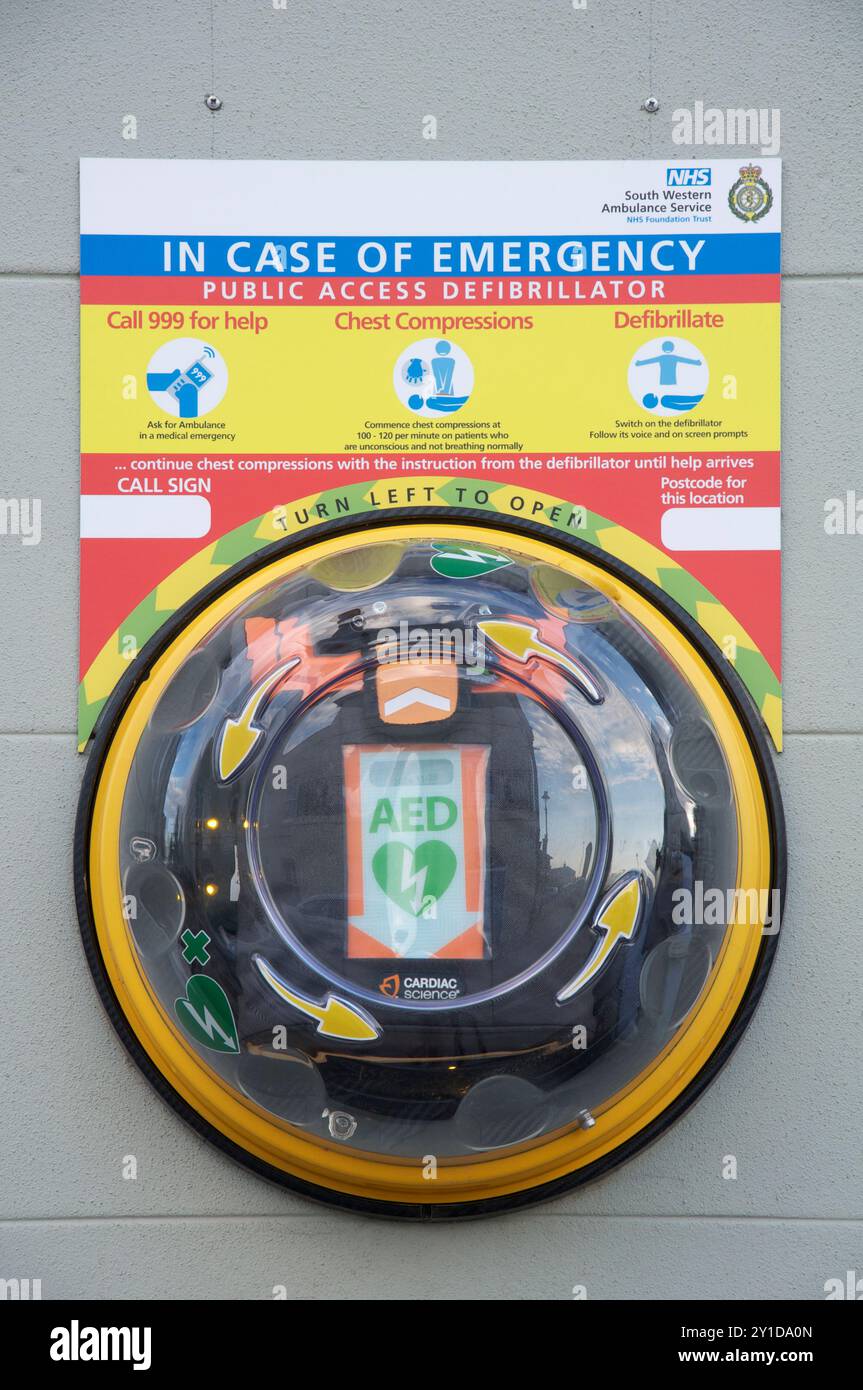 Automatisierter externer Defibrillator (AED). Lebensrettende medizinische Notfallausrüstung in einem transparenten Wandbehälter. Poundbury, Dorset, England Großbritannien Stockfoto