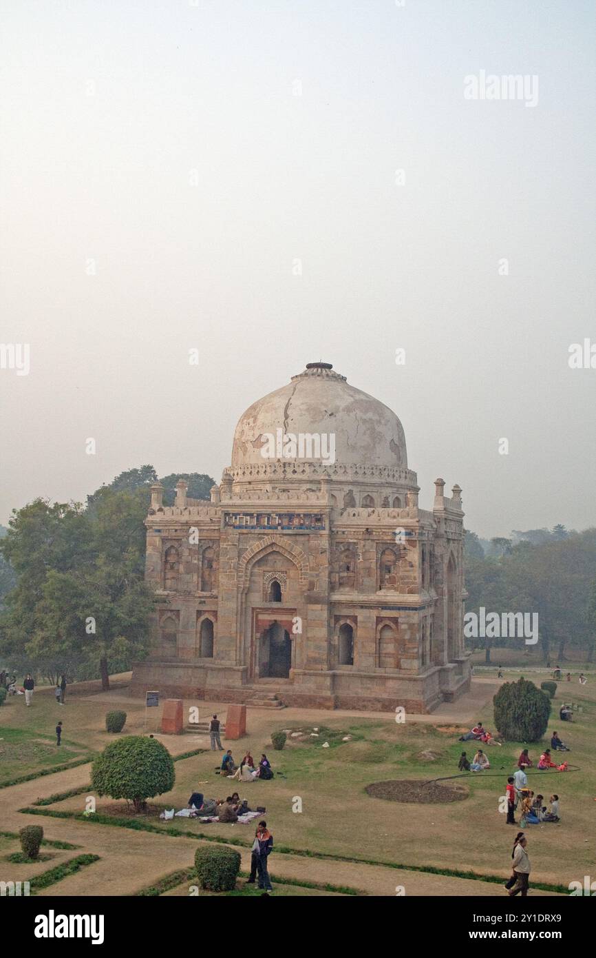 Das Sheesh Gumbad, Lodhi Gardens, Neu-Delhi, Indien. Umgeben von Gärten mit Rasenflächen, auf denen die Leute sitzen und sich amüsieren. Stockfoto