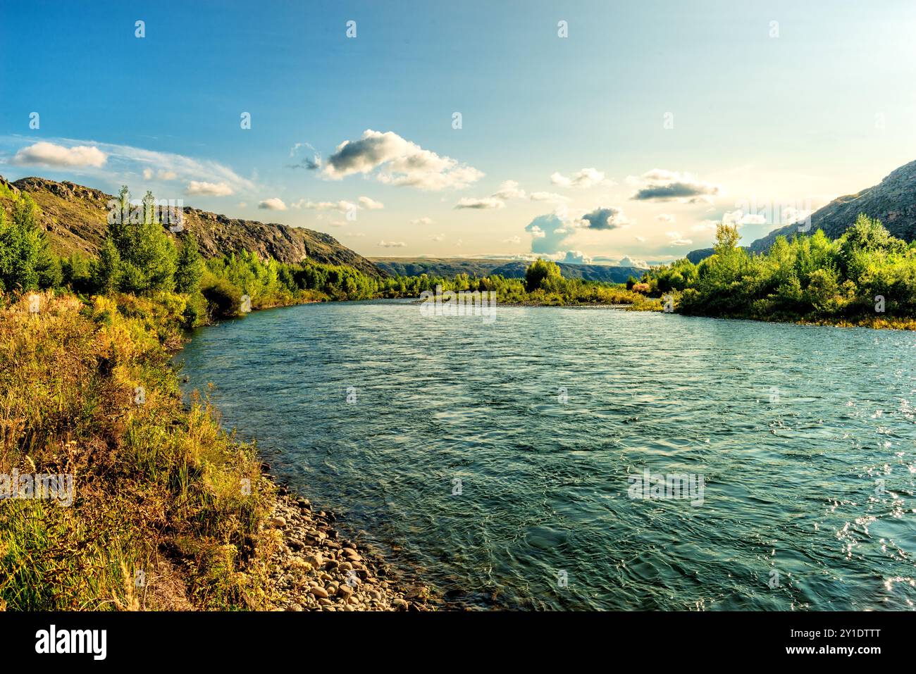 Landschaft eines Flusses, der durch eine Ebene zwischen Bergen fließt Stockfoto