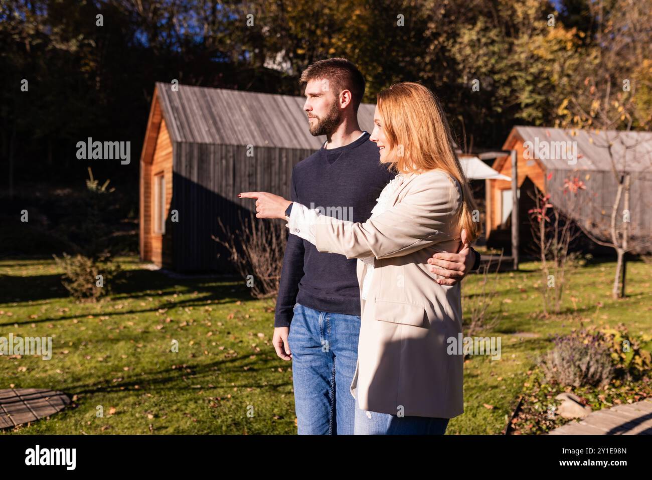 Umarmtes Paar genießt atemberaubende umliegende Landschaften des Glamping Resorts. Naturerlebnis und Entspannungskonzepte. Stockfoto