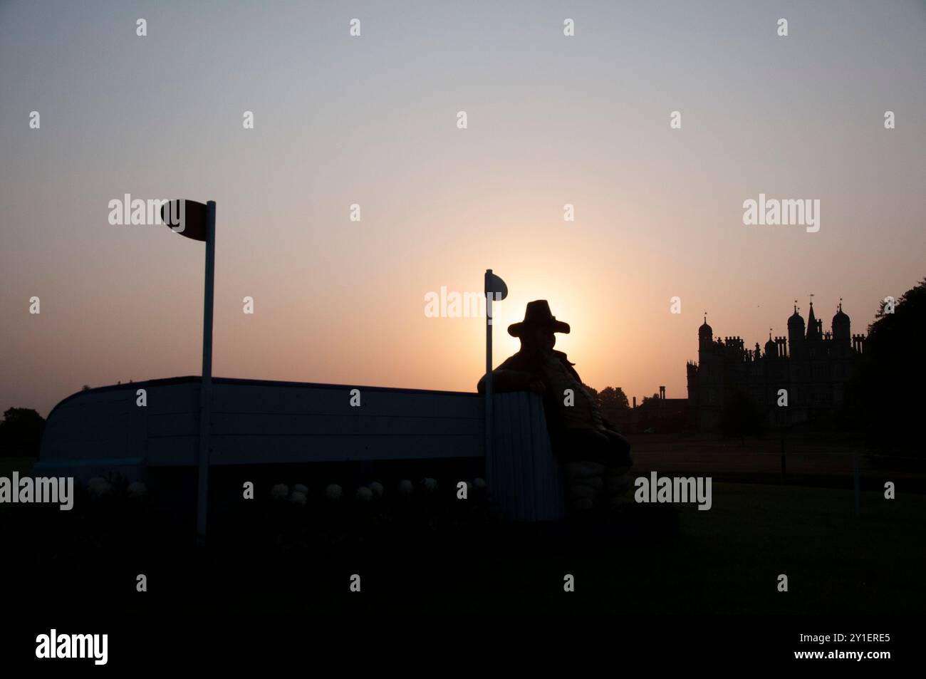 Stamford, Großbritannien. September 2024. Die Sonne geht über Burghley House und dem von Daniel Lambert inspirierten Zaun am 2. Tag der Defender Burghley Horse Trials 2024 auf dem Gelände von Burghley House in Stamford, Lincolnshire, England, Großbritannien. Quelle: Jonathan Clarke/Alamy Live News Stockfoto