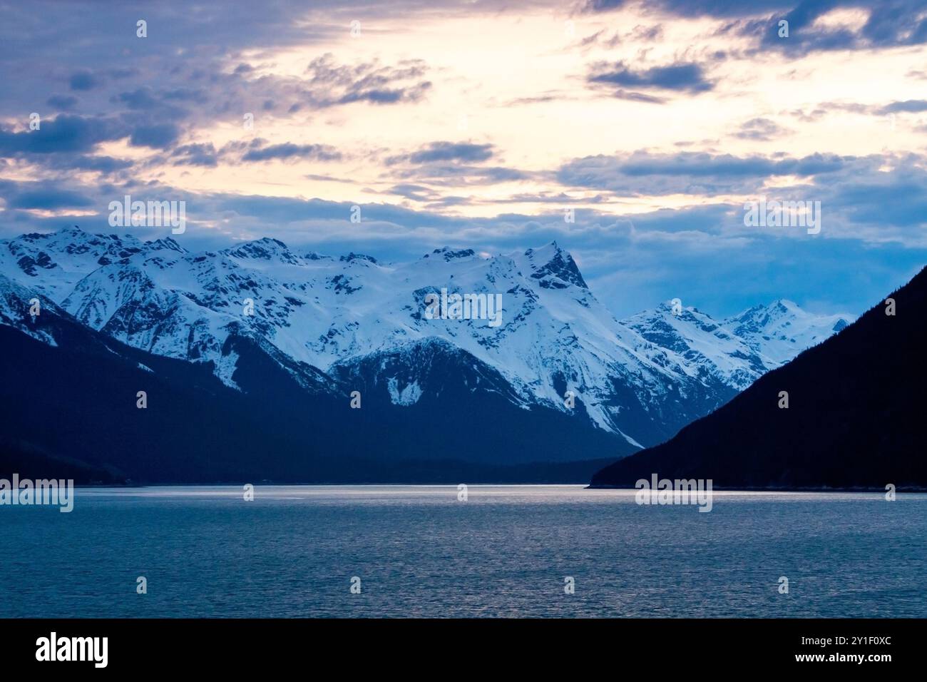 Schneebedeckte Berge in der Abenddämmerung entlang des Chilkoot Inlet bei Haines, Alaska Stockfoto