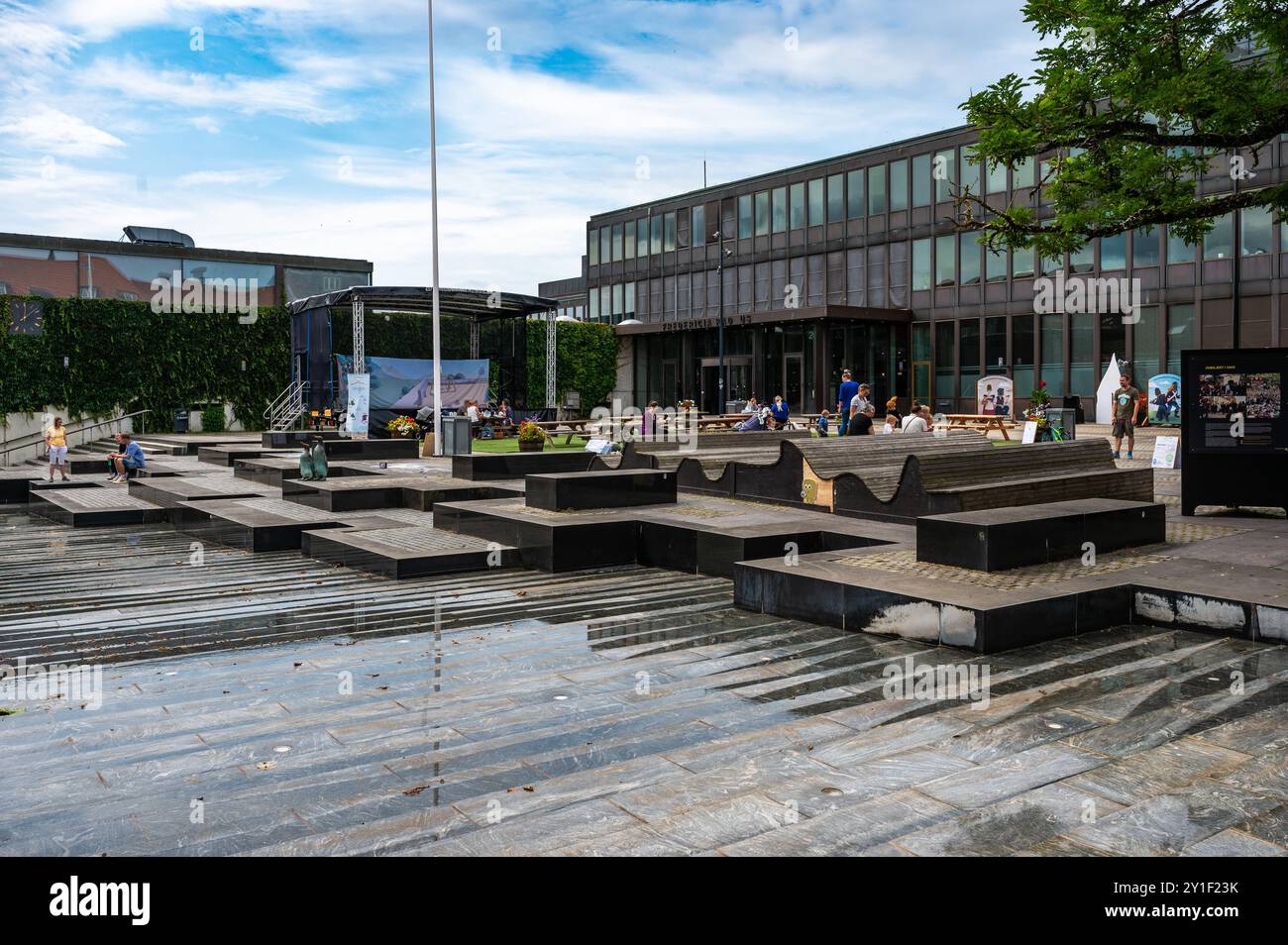 Fredericia, Jütland, Dänemark, 25. Juli 2024 - modernes Rathaus und Platz mit Menschen auf Banken Stockfoto