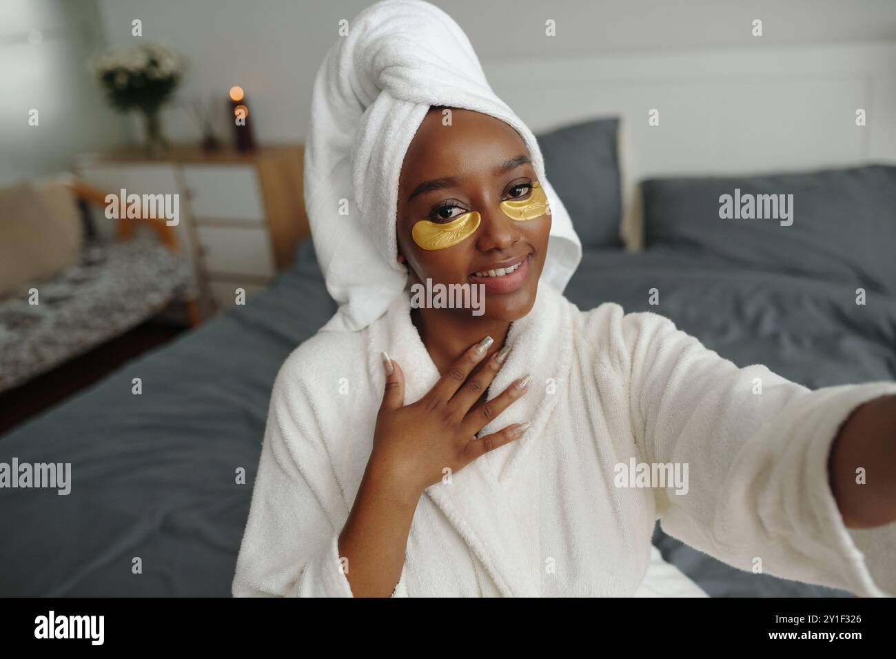 Tragen Sie Gesichtsmaske und Handtuch Turban während der Selfie-Einnahme Stockfoto