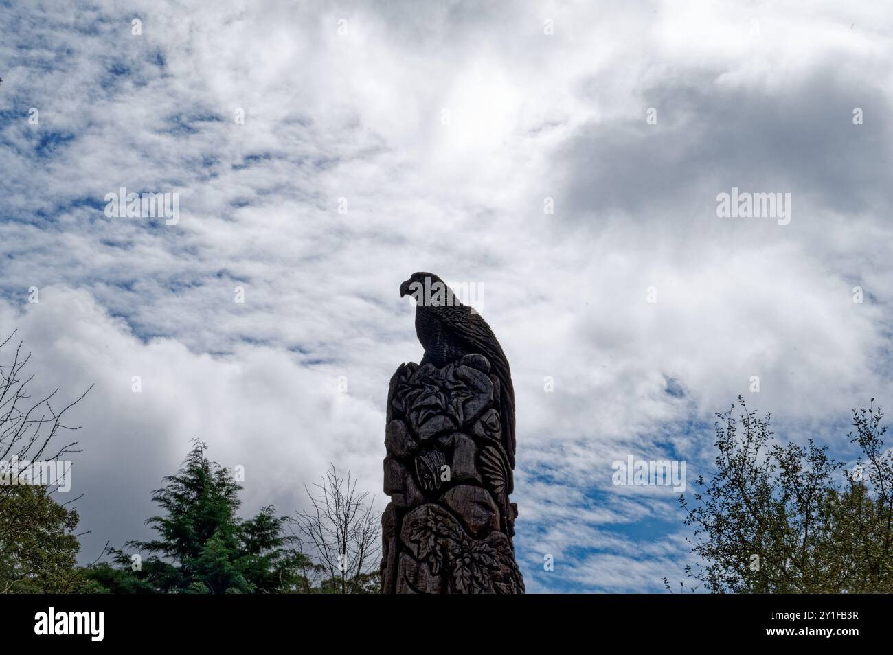 Hölzerne Adlerskulptur auf einer geschnitzten Säule unter einem bewölkten Himmel in Sintra Stockfoto