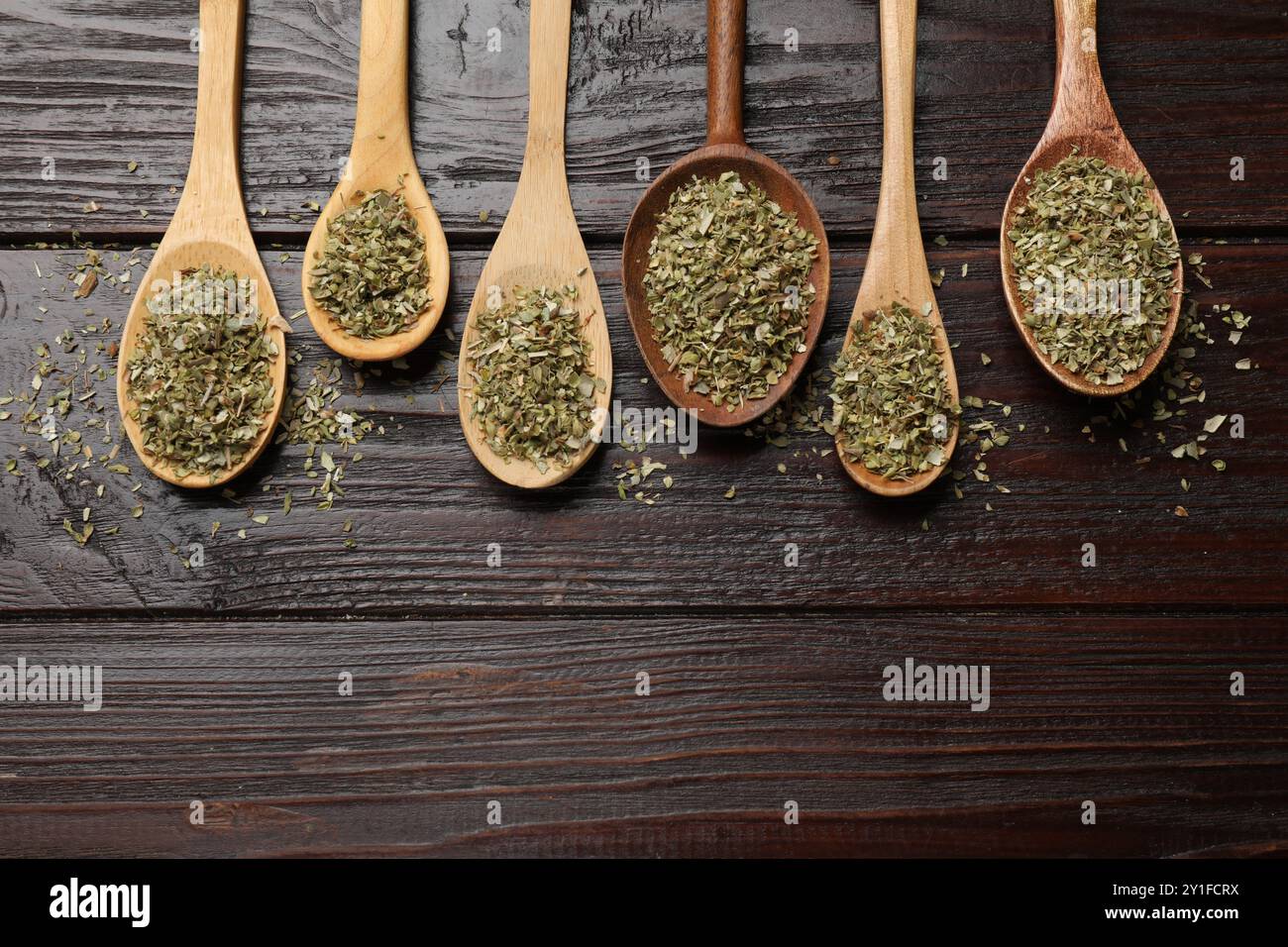 Getrockneter Oregano in Löffeln auf Holztisch, flach gelegt Stockfoto