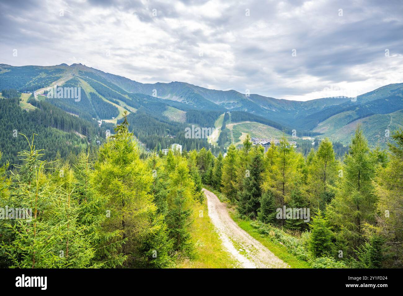 Das Jasna Mountain Resort liegt unter dem Berg Chopok und bietet einen atemberaubenden Blick auf üppige Wälder und schneebedeckte Gipfel, perfekt für Outdoor-Aktivitäten das ganze Jahr über im Demanovska-Tal, Slowakei. Stockfoto