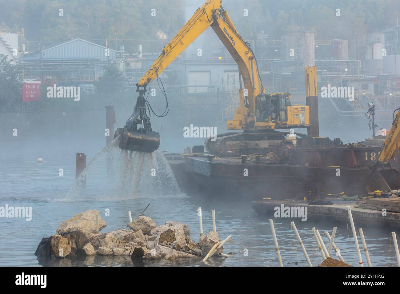 Die Bauunternehmer des U.S. Army Corps of Engineers Pittsburgh District verwenden einen Klappenbagger, um Schutt aus einem Staudamm mit festem Kamm an den Monongahela River Locks and Dam 3 in Elizabeth, Pennsylvania, am 5. September 2024 zu entfernen. Das U.S. Army Corps of Engineers Pittsburgh District eröffnete am Donnerstag, 5. September, einen 100 Fuß breiten Navigationskanal für Handelsschiffe durch die Mitte des Damms bei den Monongahela River Locks und Dam 3 in der Nähe von Elizabeth, Pennsylvania. Das erste kommerzielle Schiff fuhr am Morgen durch den Kanal. Der Kanal hat eine 56-Fuß-Breitenbegrenzung und eine 9-Fuß-Zugfestigkeit Stockfoto