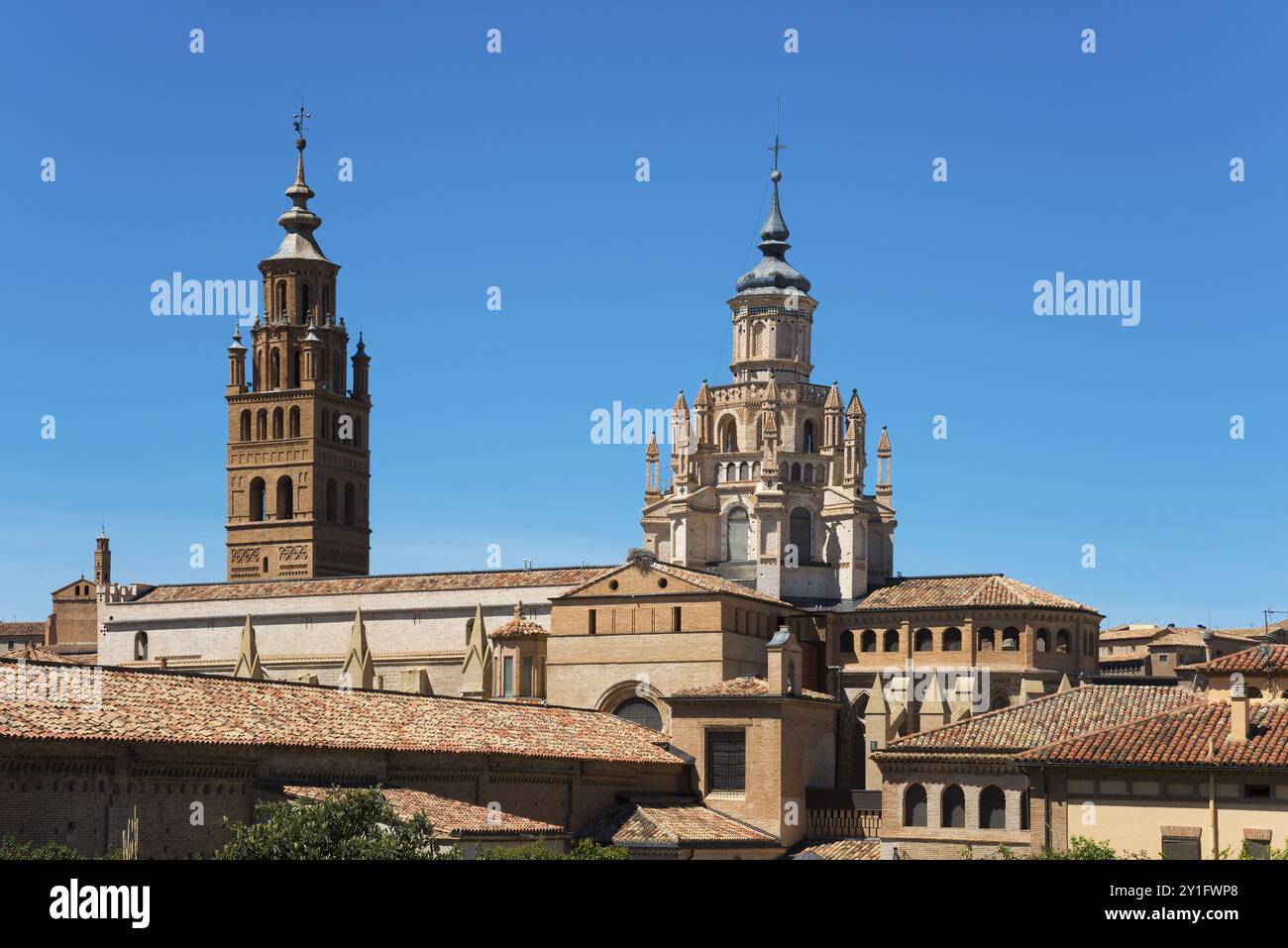 Historische Kirche mit mehreren Türmen und Backsteinfassade vor einem klaren blauen Himmel, Kathedrale, Catedral de Santa Maria de la Huerta, Tarazona, Saragoza Stockfoto