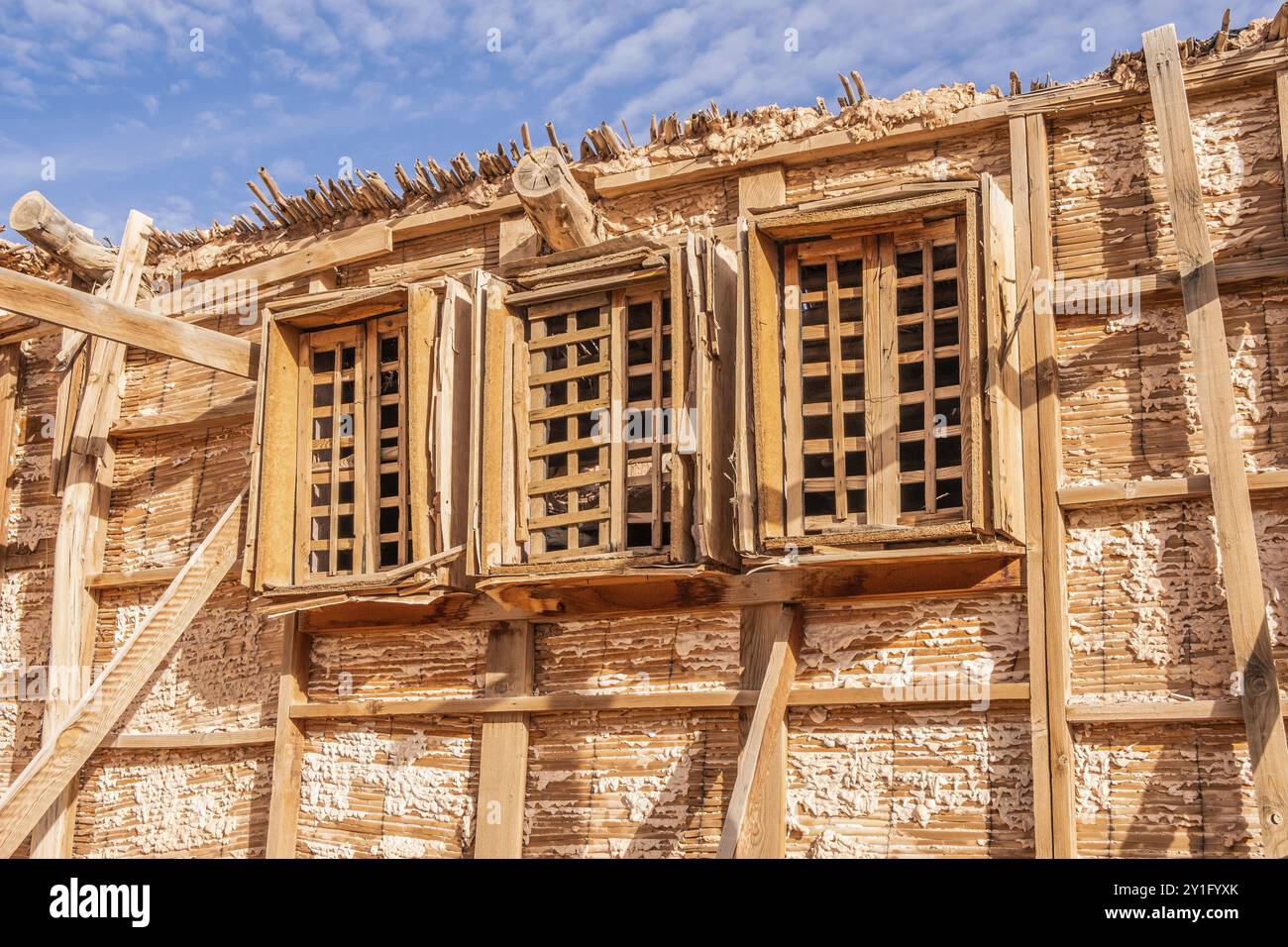 Das Haus wurde mit dünnen, hellen Holzlatten und einem blauen Himmel als Hintergrund erbaut Stockfoto