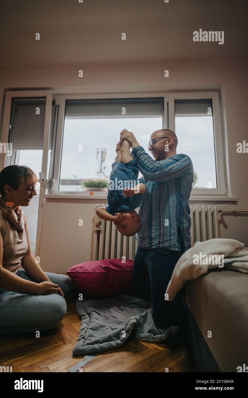 Glückliche Familie, die eine spielerische Zeit mit ihrem Kind zu Hause genießt Stockfoto