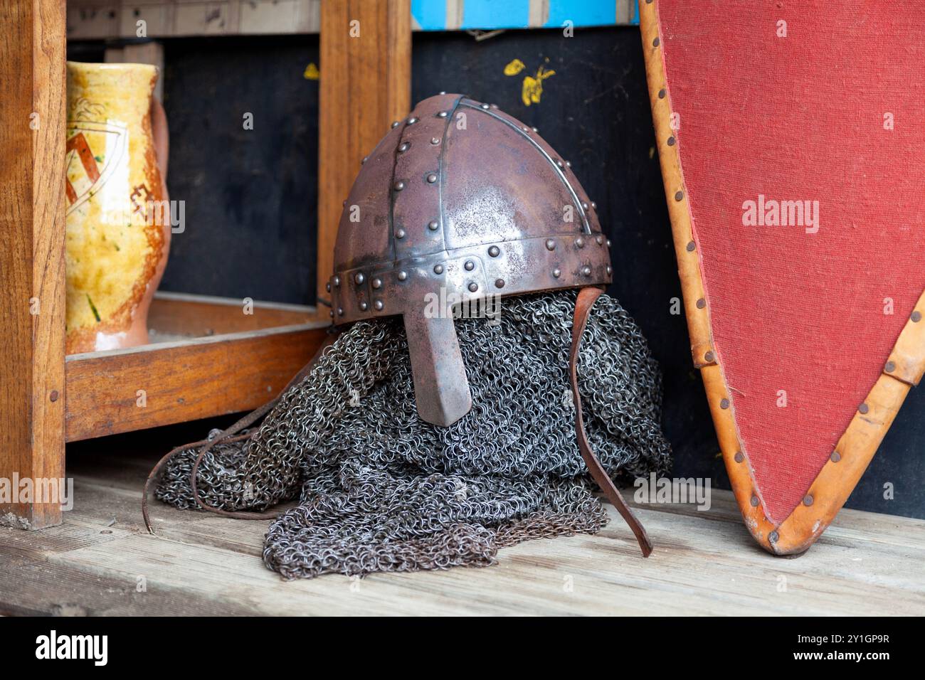 Ein normannischer Nasenhelm und seine Postkutsche neben einem Schild aus dem Mittelalter. Stockfoto