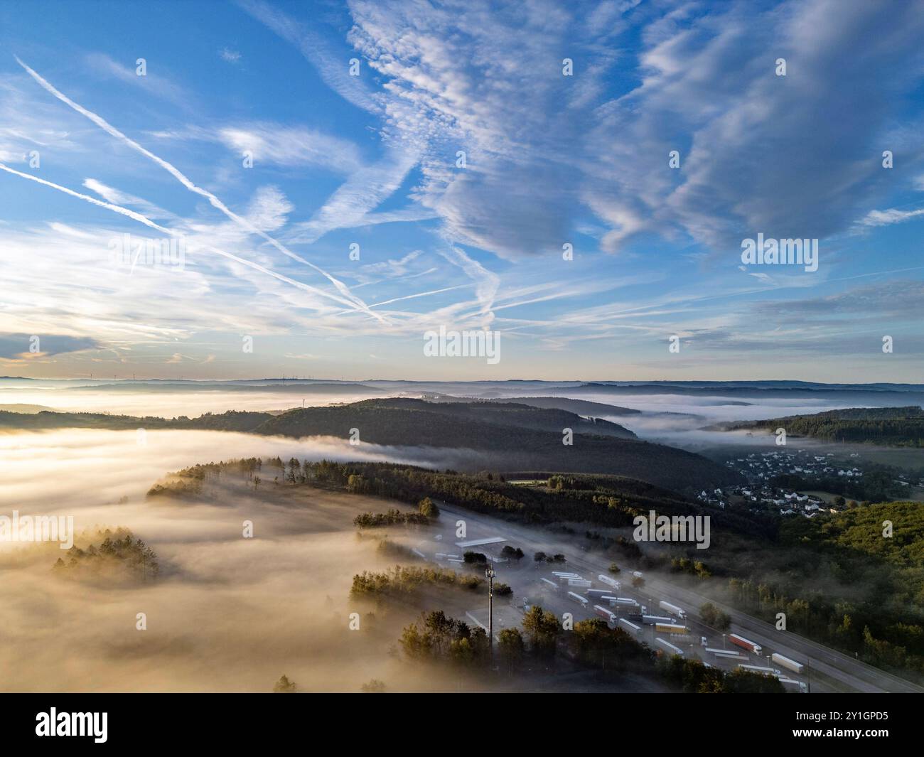 Sommermorgen im Siegerland. So langsam wird es Herbstlich. Luftaufnahme der Landschaft in der Nähe von Siegen-Oberschelden rechts. In den Taelern Tälern liegt Nebel. Im Vordergrund die Raststaette Raststätte Siegerland Ost an der Autobahn A45. Sommer im Siegerland am 07.09.2024 in Siegen/Deutschland. *** Sommermorgen in Siegerland so langsam wird es herbstlich Luftaufnahme der Landschaft bei Siegen Oberschelden direkt in den Tälern liegt Nebel im Vordergrund die Raststaette Siegerland Ost auf der Autobahn A45 Sommer in Siegerland am 07 09 2024 in Siegen Deutschland Stockfoto