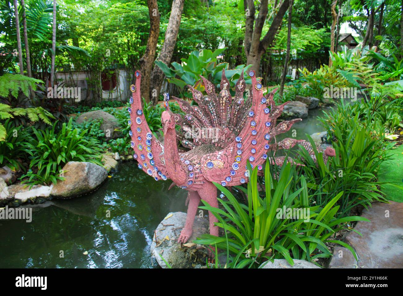Bangkok, Samut Prakan, Thailand, Südostasien, Asien. Erawan Museum. Der Museumsgarten im typisch thailändischen Stil mit einer Statue eines rosafarbenen Pfaus, Teichen und Springbrunnen. Stockfoto