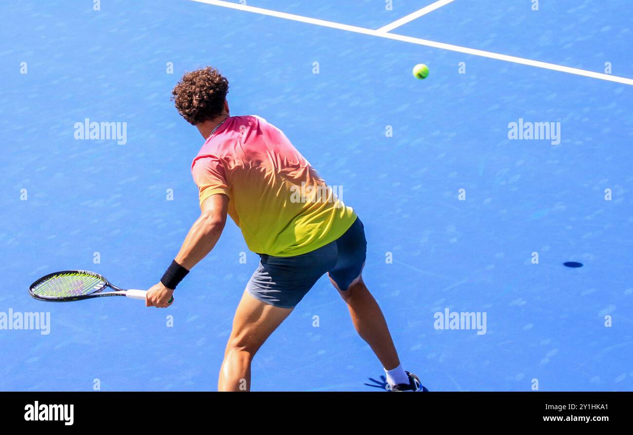 Rückansicht eines Tennisspielers, der aggressiv mit einer starken Vorderhand in Nahaufnahme schwingt, Stockfoto