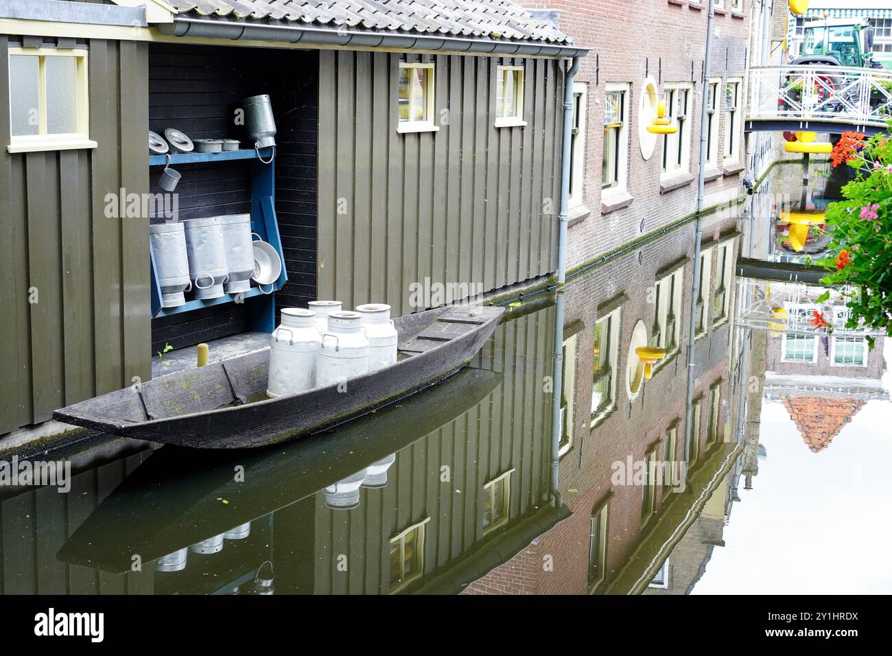 Milchkannen auf einem kleinen Boot auf dem Kanal von Gouda, berühmt für seinen traditionellen niederländischen Gouda-Käse Stockfoto