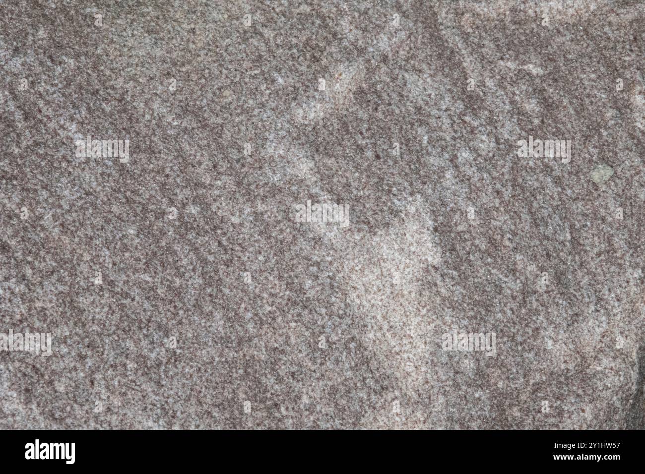 Nahaufnahme eines granulierten Gesteins. Das Gestein enthält weiß, Grau und Silber. Mit Kopierraum. Stockfoto