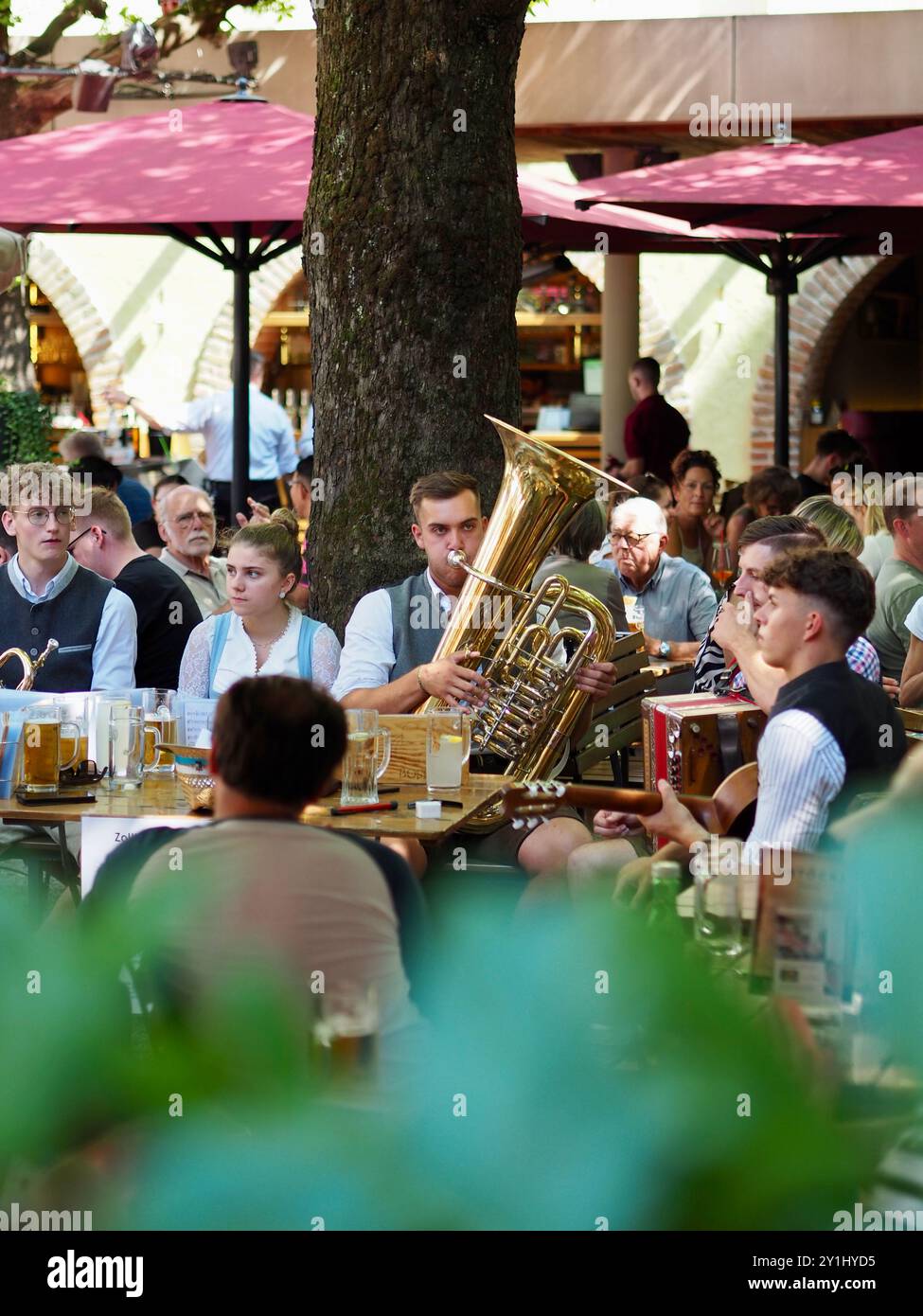 Salzburg, Österreich - 31. August 2024: Weinfest mit lokalem Musikorchester in traditioneller Volkskleidung, umgeben von Touristen, die ihre Mea genießen Stockfoto