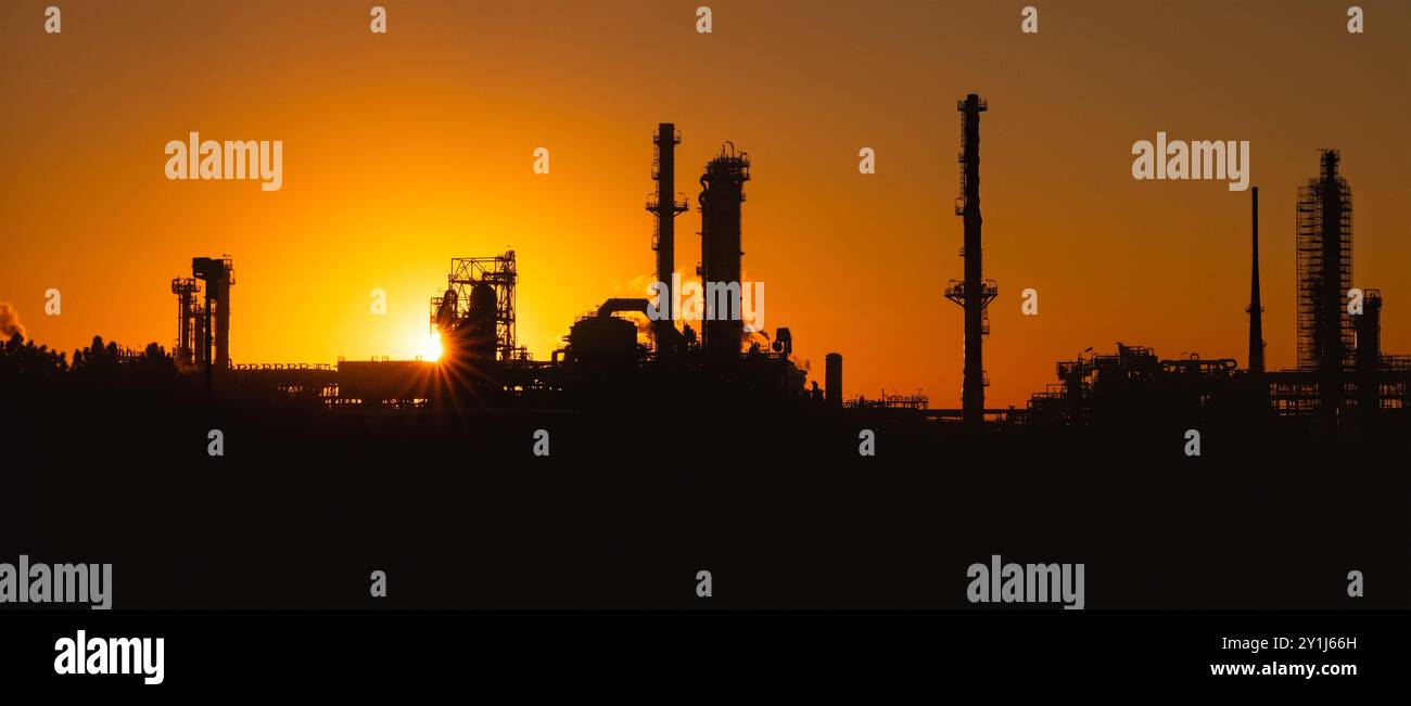 Erdöl- und Erdgasraffinerieanlage bei Sonnenuntergang – Energie- und Industriegeschichte Stockfoto