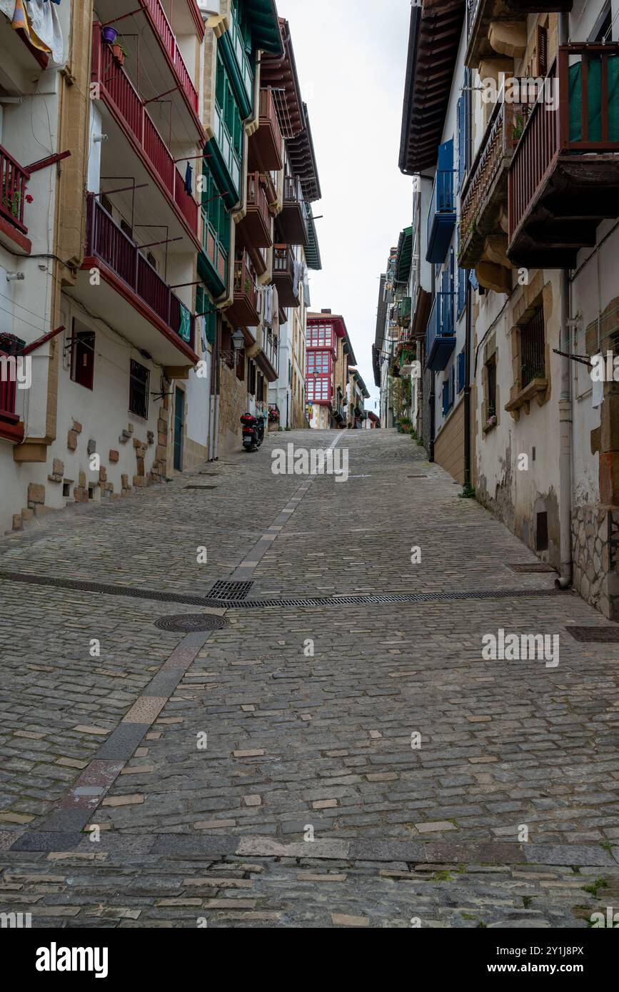 Eine steile Straße bergauf im Zentrum von Hondarribia, am letzten Ufer der Mündung des Flusses Bidasoa, gegenüber Hendaye in Frankreich. Es ist das spanische Zitat Stockfoto