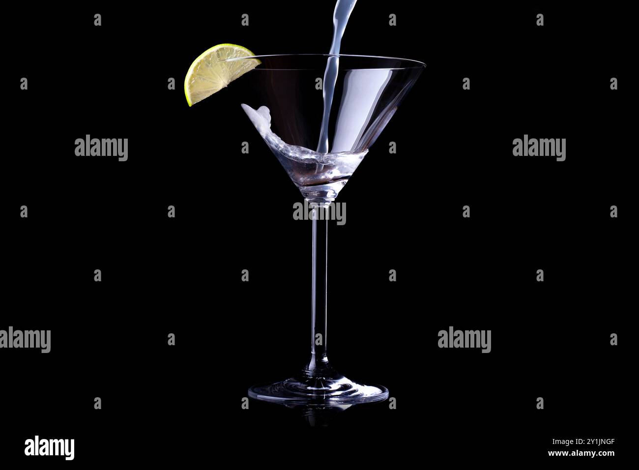 margarita wird in ein Martini-Glas gegossen. Isoliert auf Schwarz. Leeres Leerzeichen für Text Stockfoto
