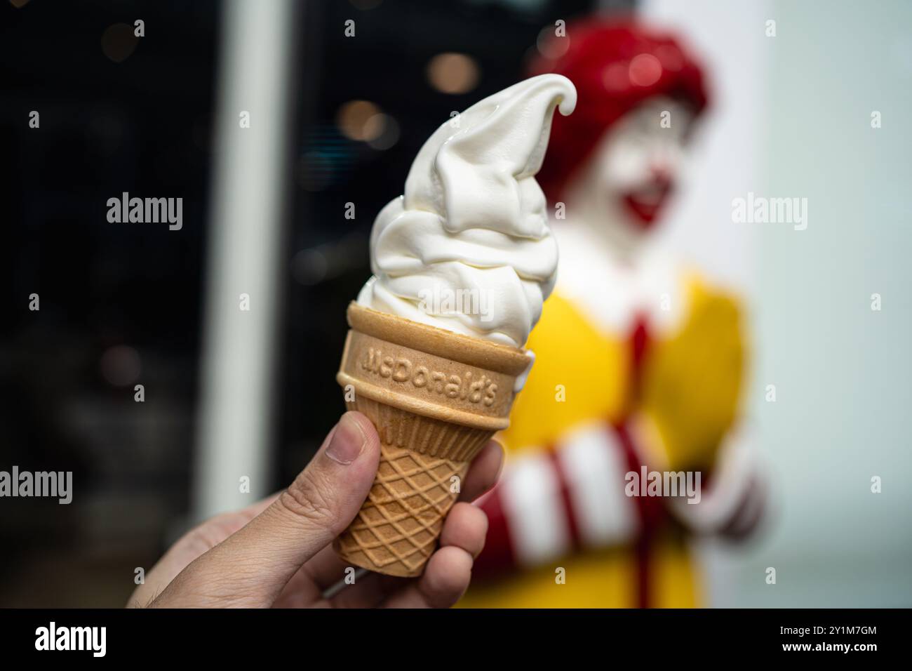 Bangkok, Thailand - 24. Mai 2024: Ein Mann hält McDonald's Vanillekegel vor dem Restaurant. Stockfoto