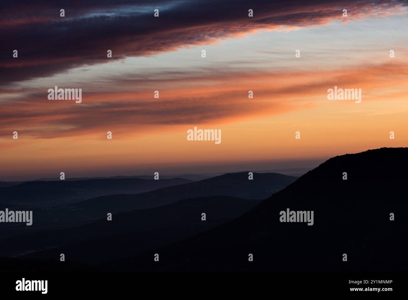 Bunte Wolken leuchten am Himmel bei Sonnenuntergang über den Galiläischen Bergen im Norden Israels. Stockfoto