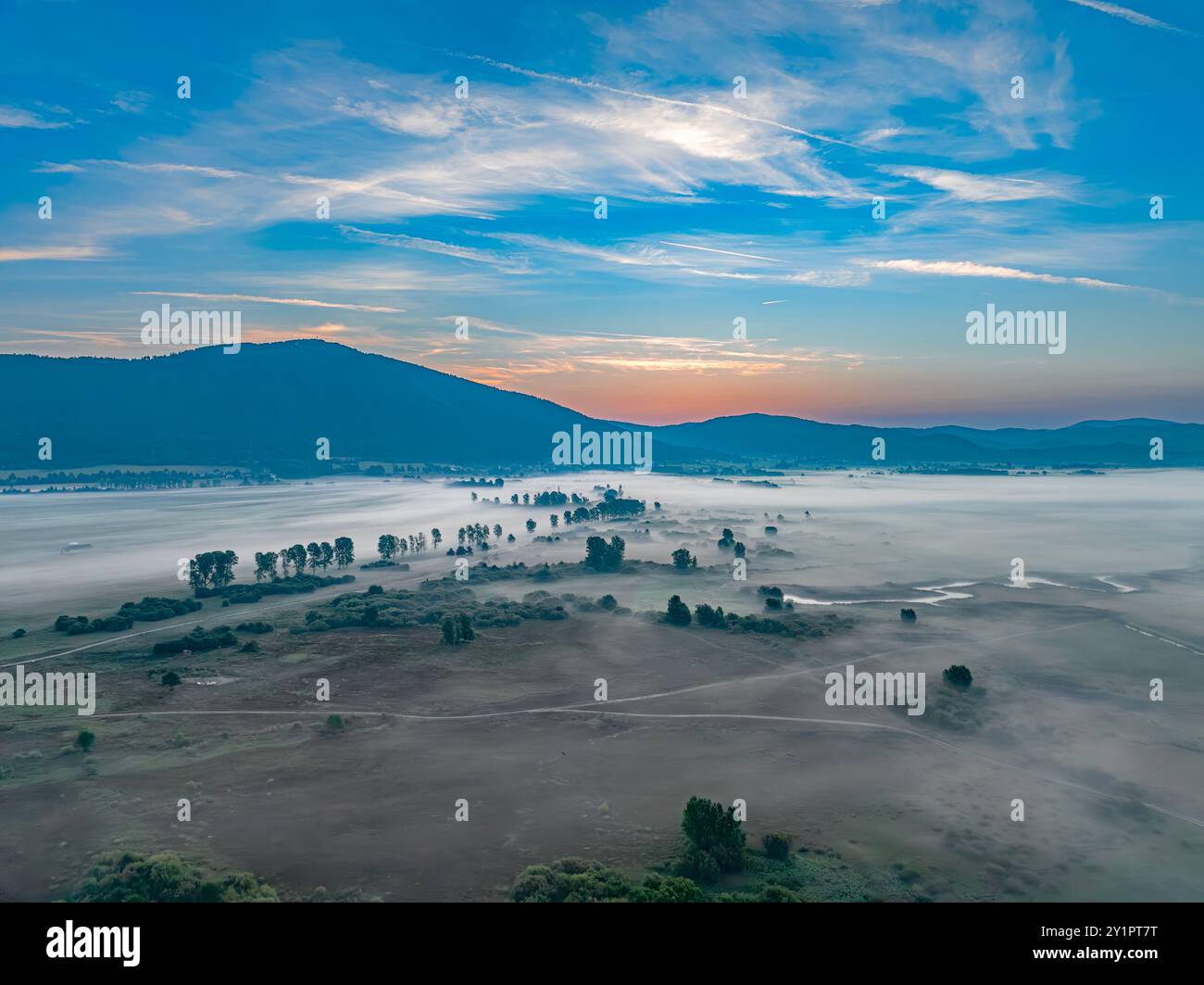 Nebeliger Morgen am leeren, intermittierenden See Stockfoto