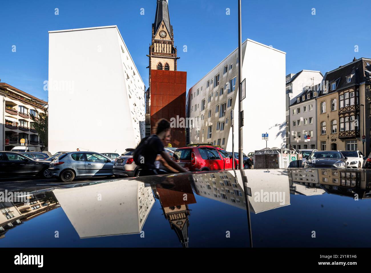 Die evangelische Christuskirche im Belgischen Viertel spiegelt sich in einem Autodach in Köln wider. 2014 wurde das Kirchenschiff abgerissen, um eine Re zu bauen Stockfoto