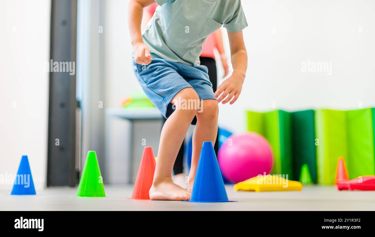 Junge beim Training mit Physiotherapeutin während der Therapiesitzung. Ergoskopische Therapie des Kindes. Bilaterale Koordinierung. Stockfoto