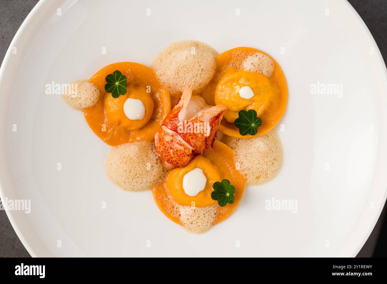 Ravioli mit gegrillten Garnelen auf einem weißen Porzellanteller Stockfoto