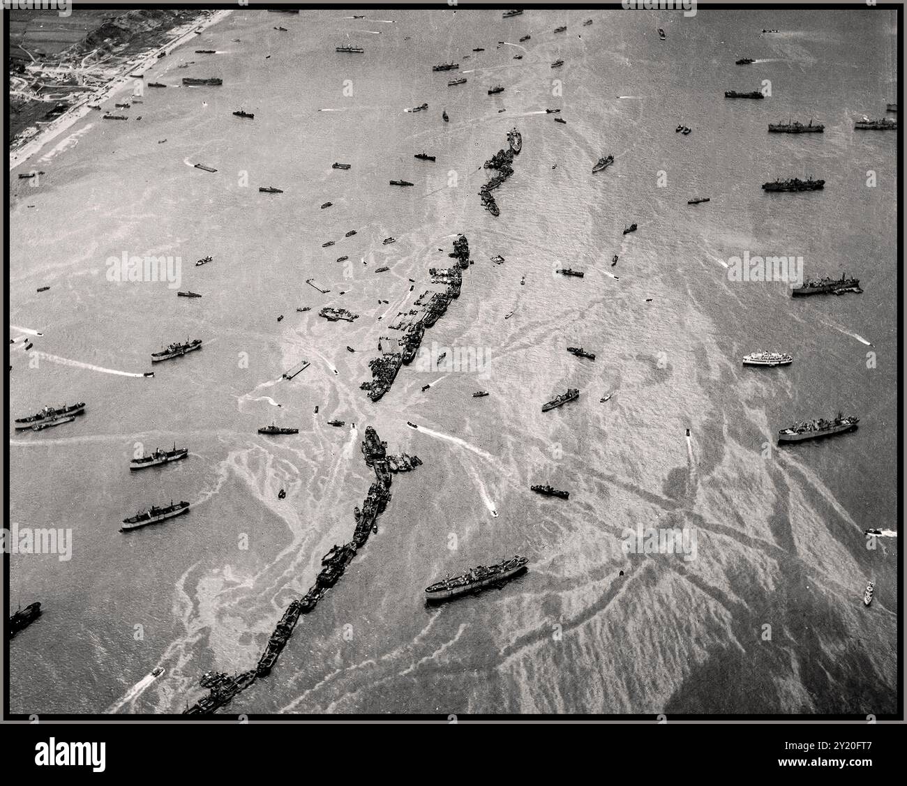 D-DAY INVASION DER NORMANDIE Overhead-Ansicht der Schiffe der American Liberty, die als provisorische Wellenbrecher vor den Stränden der Normandie fungieren, Juni 1944. Dutzende Schiffe, die für die Zwecke dieser Operation „Maiskolben“ genannt wurden, wurden absichtlich etwa 1.000 Meter vor der Küste versenkt, um „Gooseberry“-Wellenbrecher für die künstlichen Mulberry-Häfen bei Omaha und Gold Beaches zu schaffen. 2. Weltkrieg 2. Weltkrieg Stockfoto