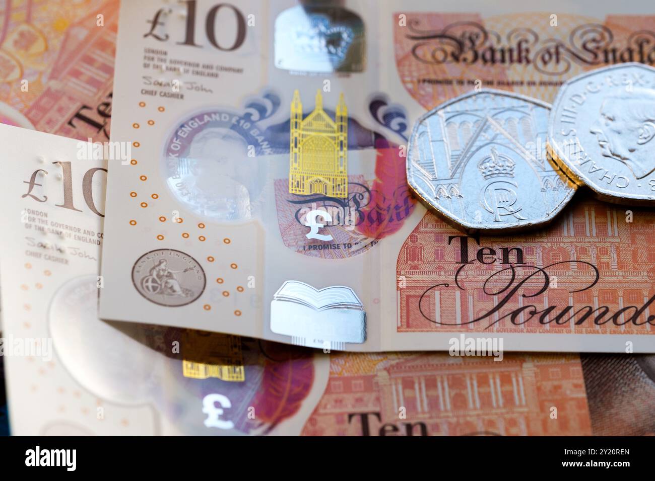 Britische Münzen und Banknoten mit König Karl III., der sich auf die neuen Devisendesigns konzentriert, darunter eine neue 50-Pence-Münze und eine 10-Pfund-Note. Stockfoto