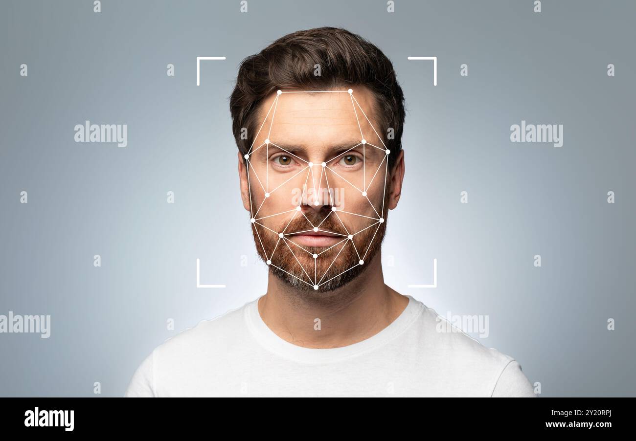 Mann mit Gesichtserkennungsgitter auf dem Gesicht vor grauem Hintergrund Stockfoto