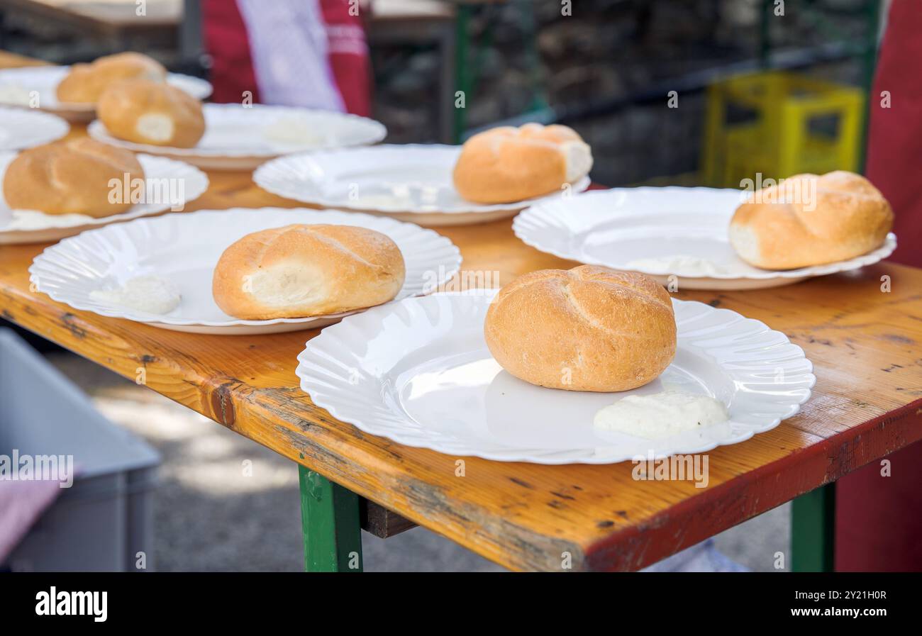 Brötchen auf weißen Tellern auf Holztisch, Esszimmer im Freien, rustikales Ambiente, Brot, Essen, rustikales Ambiente Stockfoto