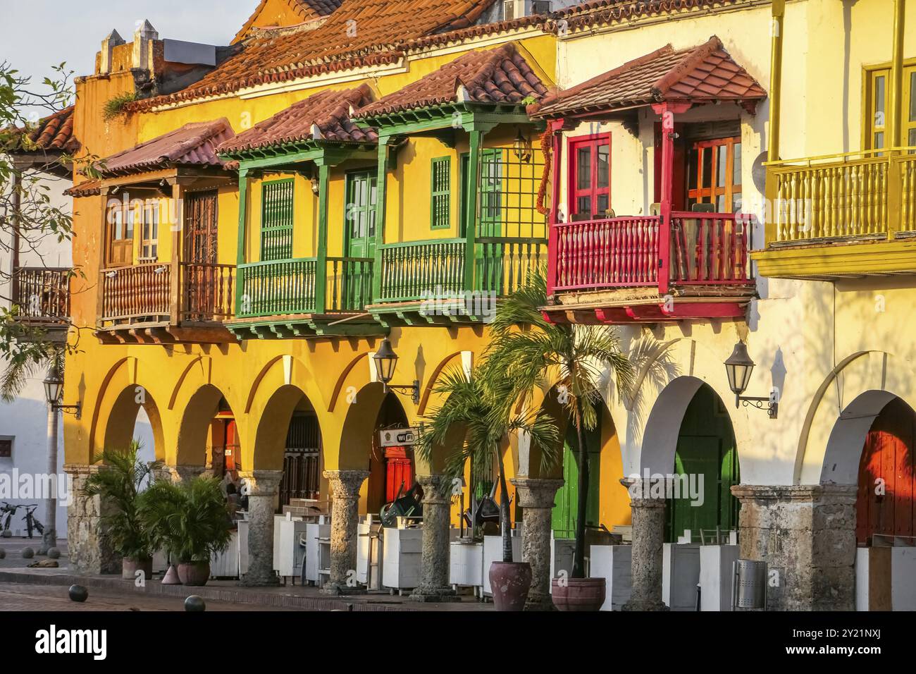 Aus nächster Nähe sehen Sie farbenfrohe historische Gebäude mit Balkonen und Bögen im warmen Sonnenlicht, Plaza de los Coches (Kutschenplatz), Cartagena, UNESCO wo Stockfoto