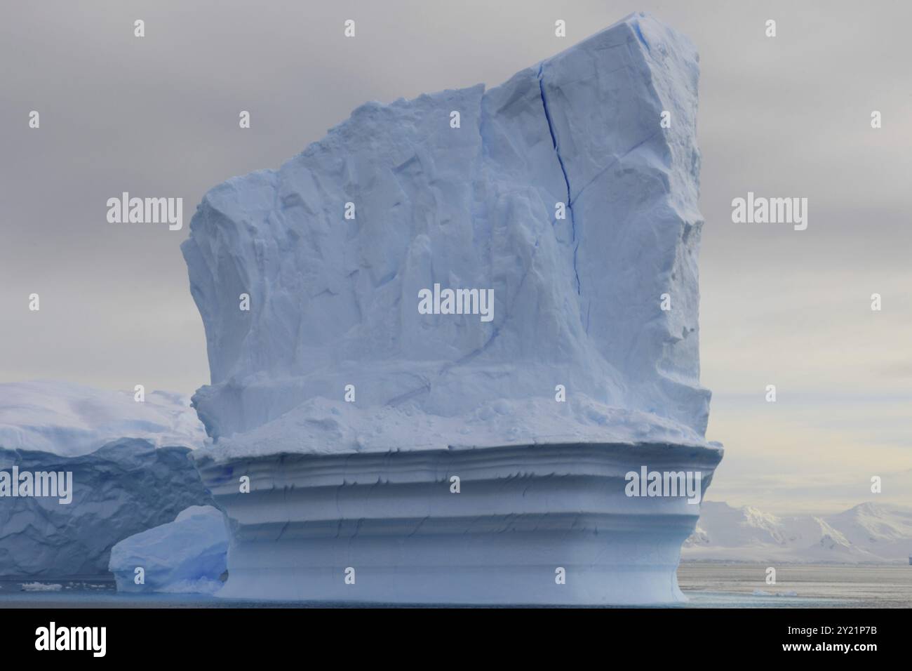 Hoch aufragender Eisberg in der Antarktis mit Wolken im Hintergrund Stockfoto