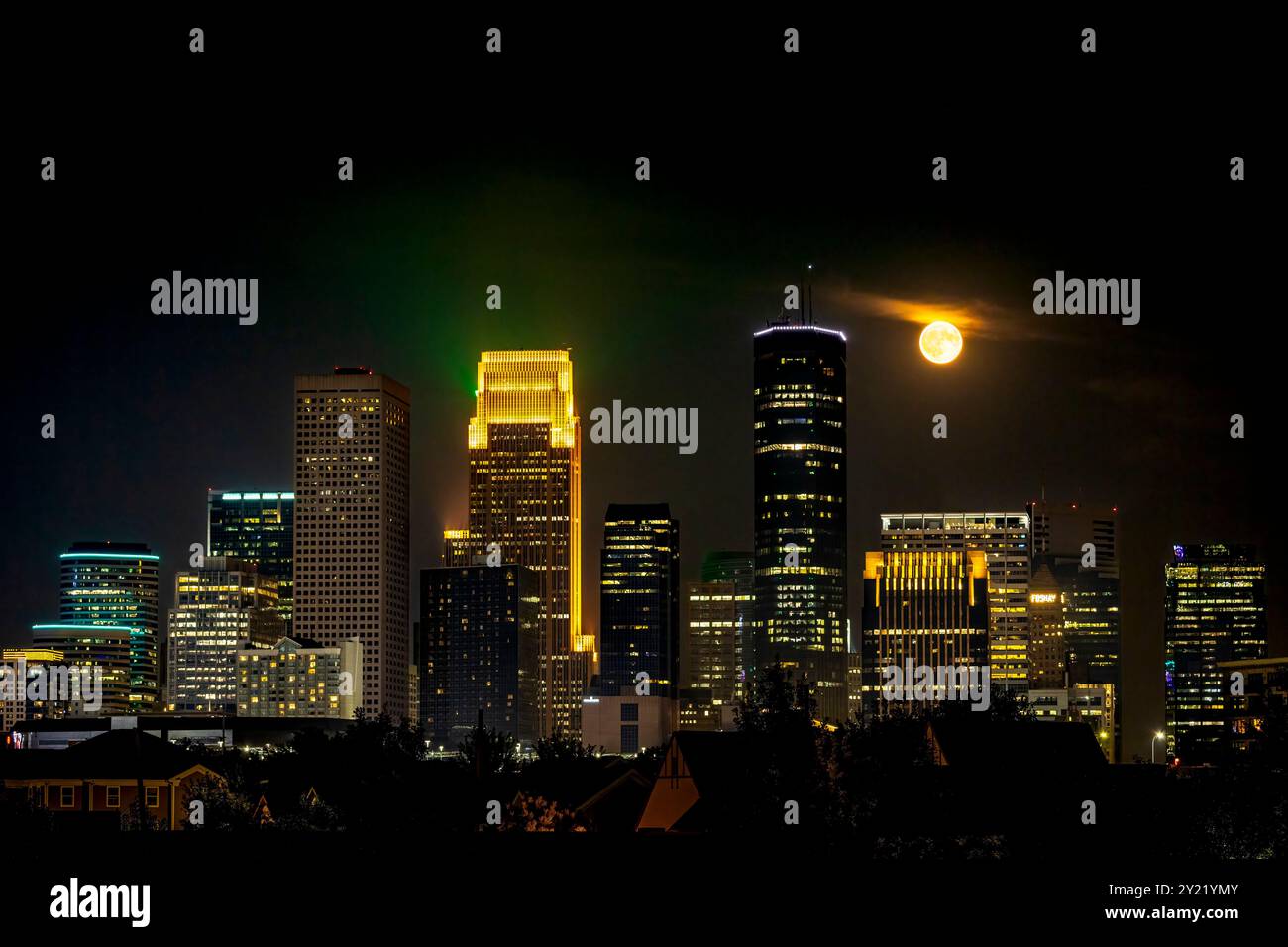 Havest Moon, der nachts über Downtown Minneapolis, Minnesota, aufsteigt und die wunderschöne Skyline der Stadt mit hellen Lichtern beleuchtet Stockfoto