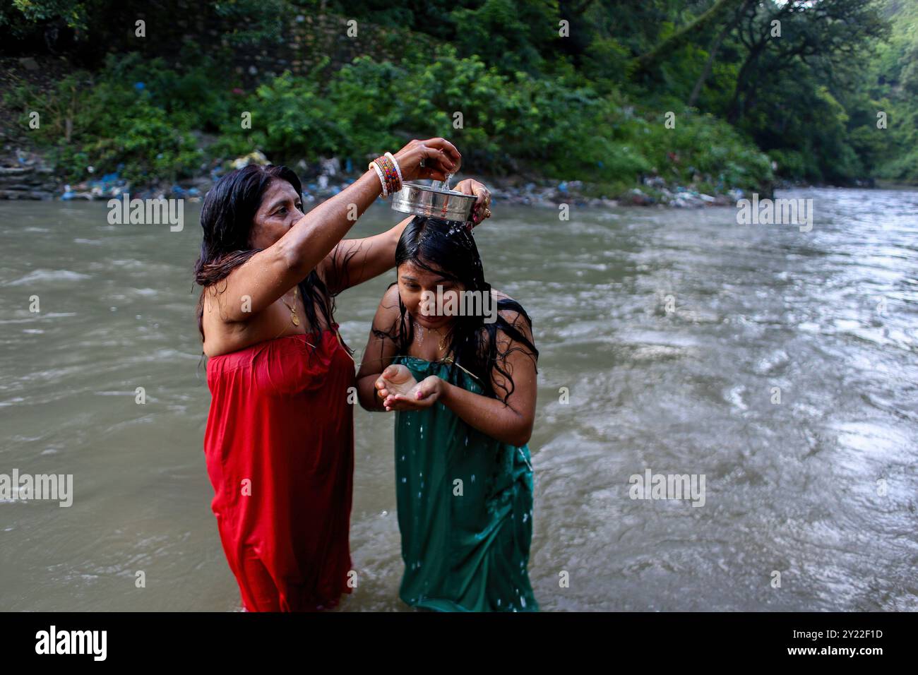 Kathmandu, Nepal. September 2024. Nepalesische Frauen führen während des Rishi Panchami-Festivals ein Ritual durch, während sie ein heiliges Bad im Bagmati-Fluss nehmen. Rishi Panchami wird am letzten Tag von Teej beobachtet, wenn Frauen Sapta Rishi (Sieben Heilige) verehren, um Vergebung für Sünden zu bitten, die während ihrer Menstruationszeit während des ganzen Jahres begangen wurden. Die Hindureligion betrachtet Menstruation als Darstellung von Unreinheit und Frauen ist es untersagt, während ihrer monatlichen Menstruation an religiösen Praktiken teilzunehmen. (Foto: Sunil Pradhan/SOPA Images/SIPA USA) Credit: SIPA USA/Alamy Live News Stockfoto