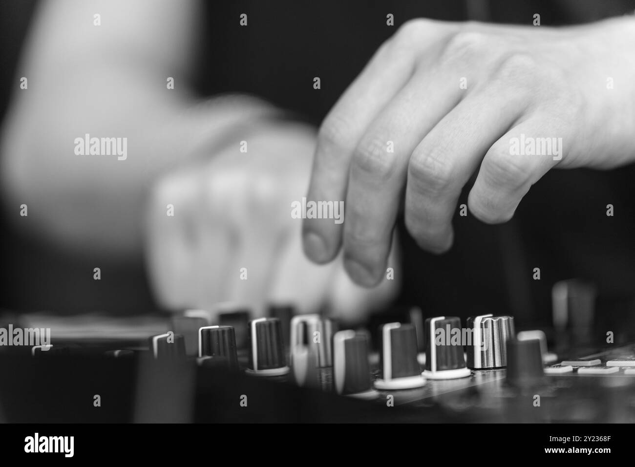 DJ Set Control Close-Up: Hand-on-Ausrüstung in Schwarzweiß Stockfoto