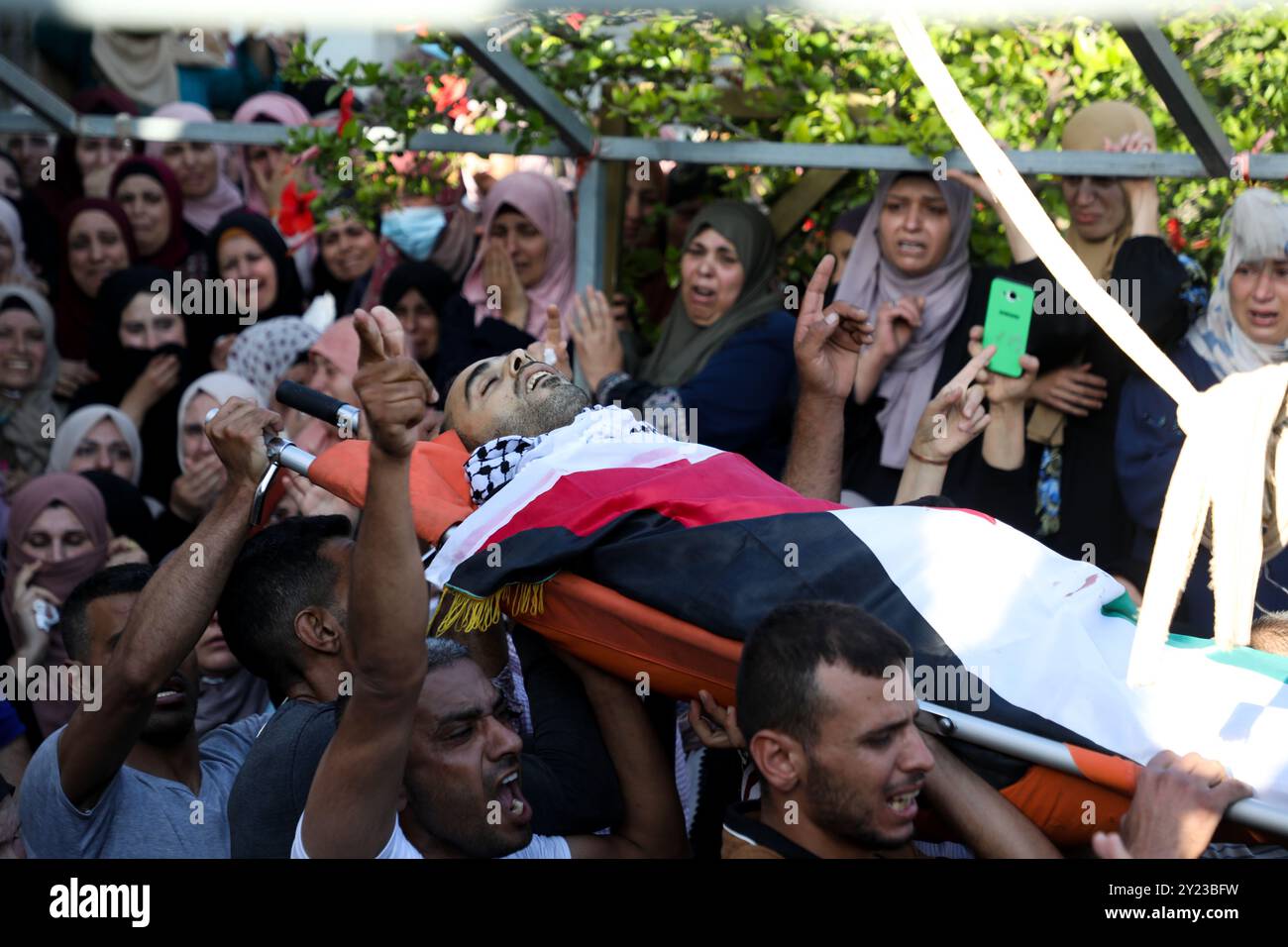 Jenin, Westjordanland, Palästina. 14. Mai 2021. Eine große Menschenmenge nimmt an der Beerdigung des 26-jährigen palästinensischen Yusef Nawasrah im Dorf Fahma, westlich von Dschenin, Teil. Yousef wurde bei Zusammenstößen mit der israelischen Armee in der Nähe der Stadt Dschenin getötet, als sich im Westjordanland Proteste ausbreiteten, die durch die derzeitige Eskalation der Gewalt zwischen palästinensischen Fraktionen in Gaza und dem israelischen Militär ausgelöst wurden. Hunderte von Raketen wurden aus Gaza auf verschiedene Orte in Israel abgefeuert, während Gaza am fünften Tag in Folge mit Luftangriffen und Artilleriegeschossen wurde. Die Zahl der Opfer steigt bei beiden sid weiter Stockfoto