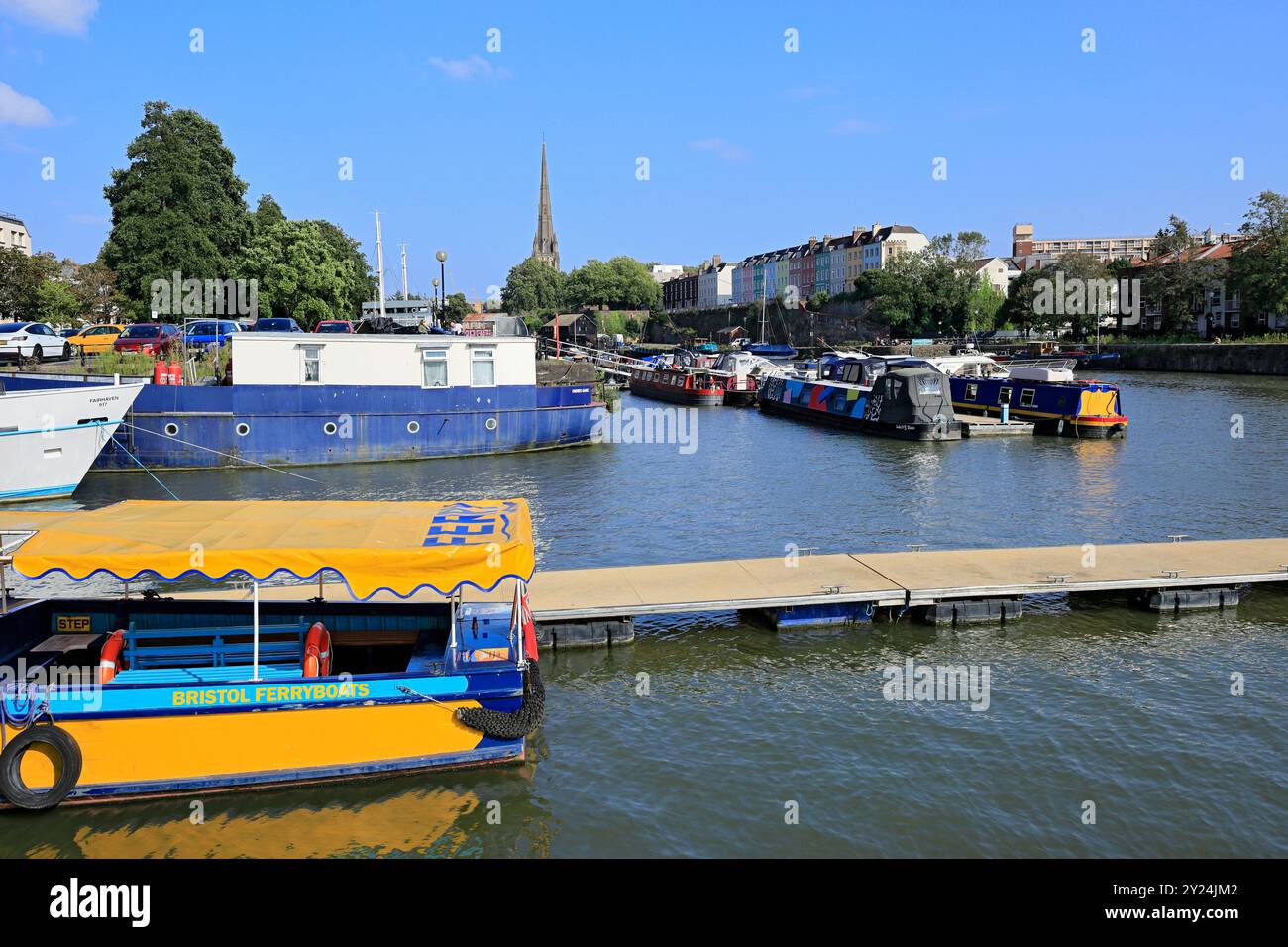 Fährschiff im schwimmenden Hafen mit den farbigen Häusern Redcliffe Parade und St. Mary Redcliffe Church, Bristol. Stockfoto