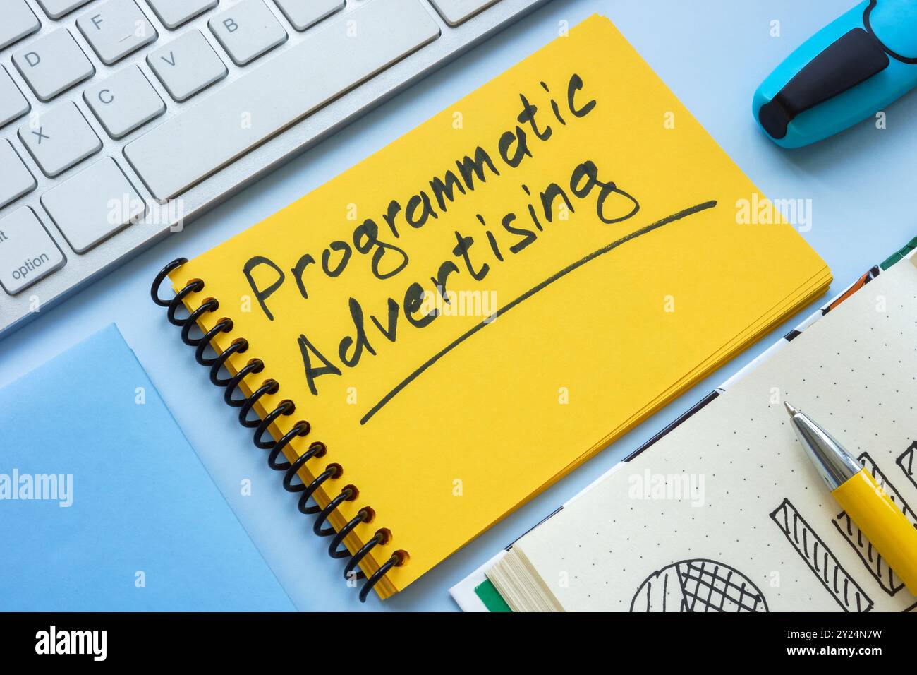 Offenes Notebook mit programmatischem Werbetext als Symbol digitaler Marketingstrategien. Stockfoto