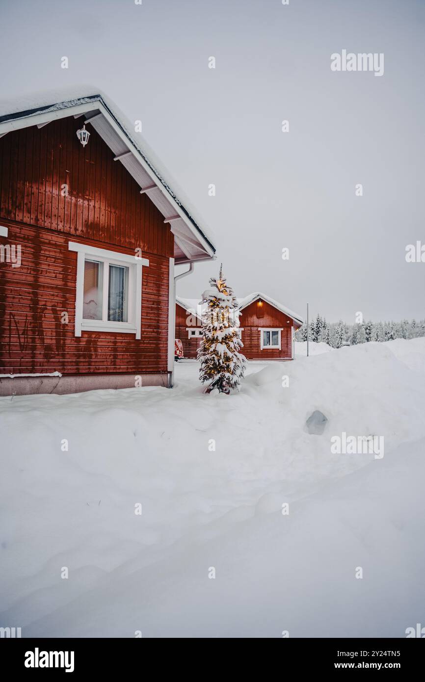 Rote Häuser im Schnee mit Weihnachtsbaum in Rovaniemi, Lappland Stockfoto