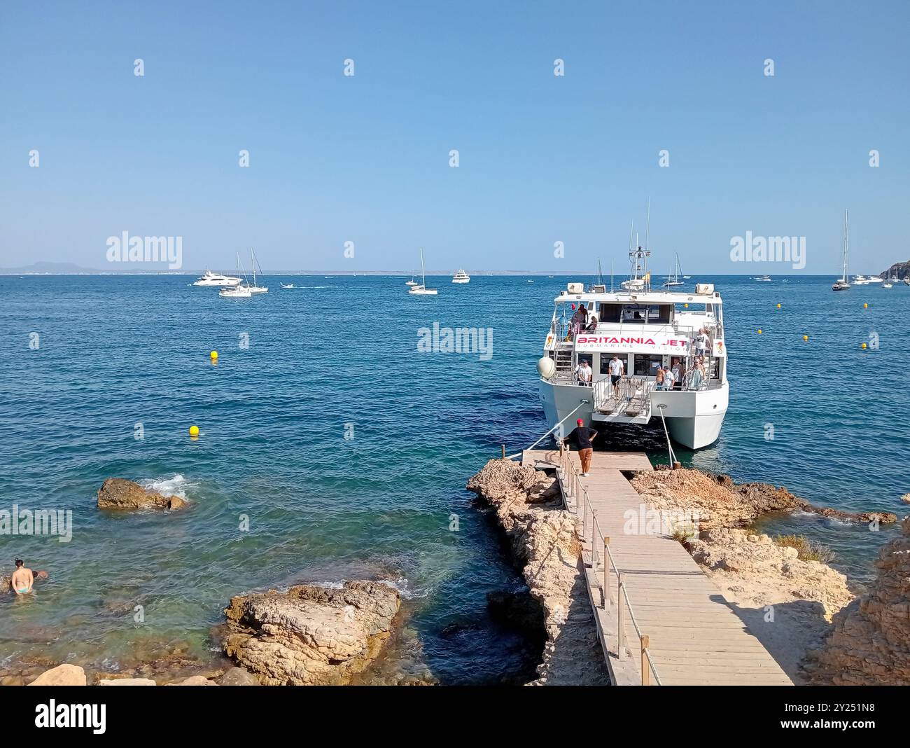 Palmanova, Spanien; 10. august 2024: Ausflugsboot mit Touristen an der felsigen Küste des mallorquinischen Kurortes Palmanova, auf einer sonnigen Insel Stockfoto