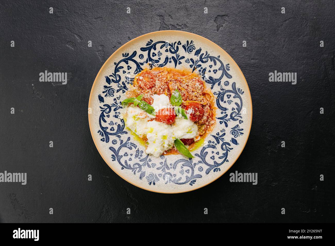 Italienische Pasta mit Kirschtomaten, Burrata und frischem Basilikum - Gourmetgericht für Feinschmecker Stockfoto