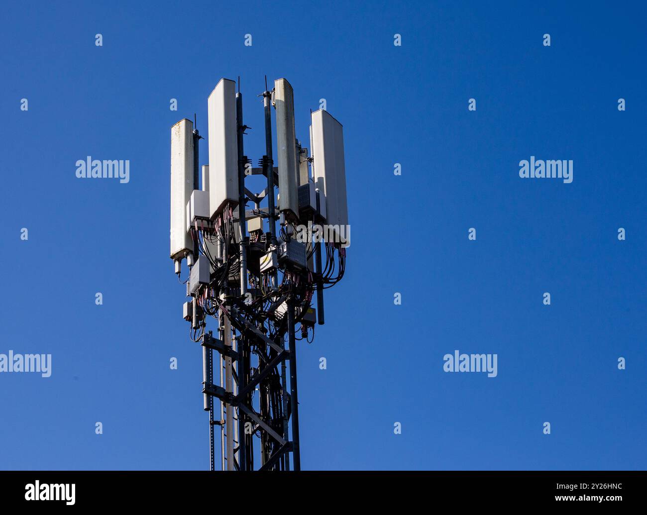 Die Spitze eines Telekommunikationsturms vor einem klaren blauen Himmel. Stockfoto